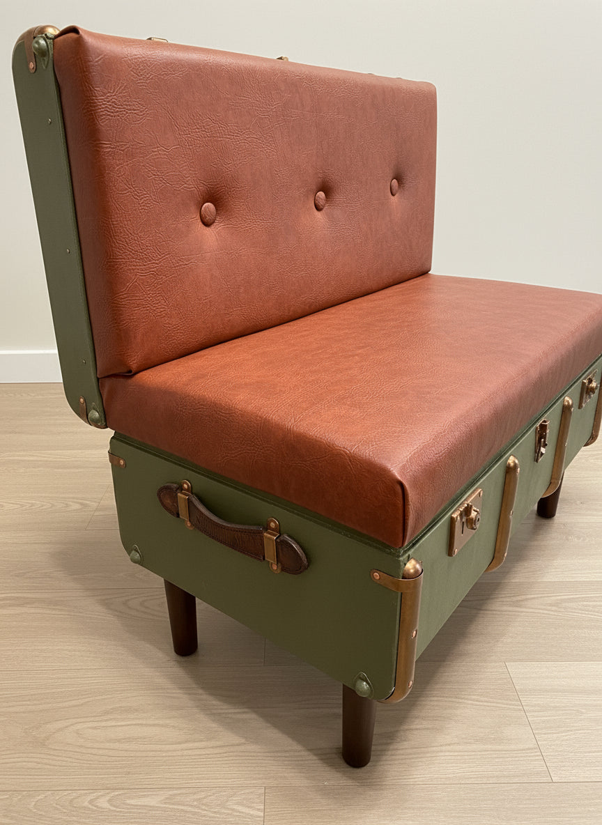 Chair made from repurposed suitcases with brown leather seat and green frame.